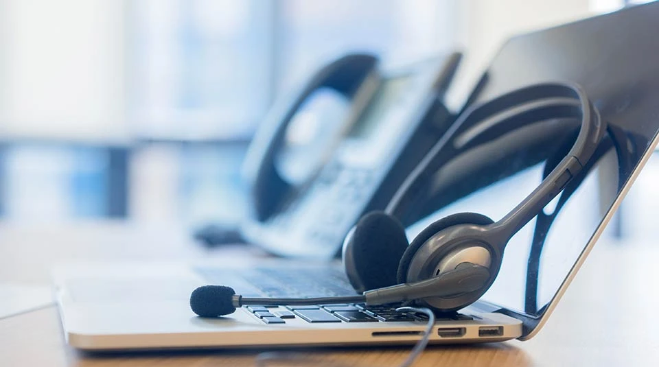 Auricolare appoggiato sopra un portatile a rappresentare la possibilità di attivare con TIM un numero verde aziendale che inizia con 800