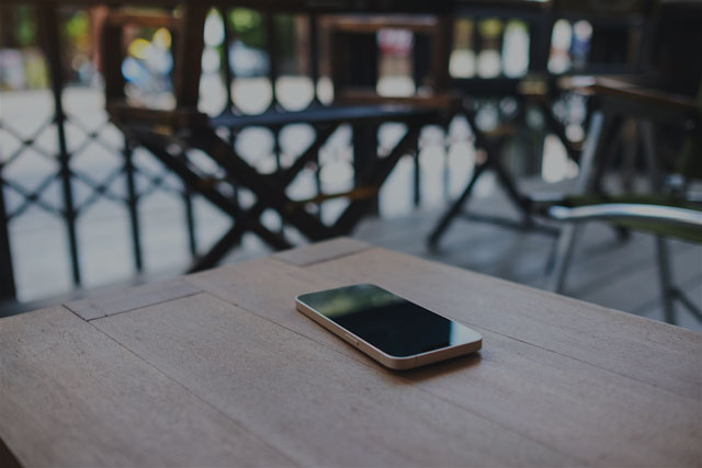 Smartphone abbandonato su un tavolo all’aperto, rappresenta la perdita del dispositivo.