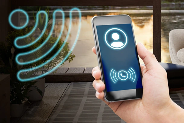 Mano maschile regge un telefono a cui sta arrivando una chiamata grazie alla copertura del wi-fi