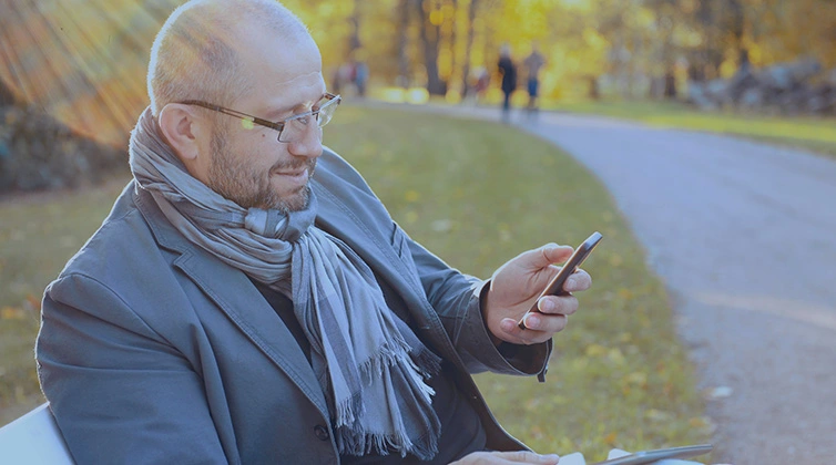 Uomo professionista utilizza uno smartphone all'aperto