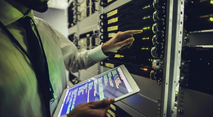 Tecnico IT che monitora sul tablet gli apparati di rete tramite il pannello di controllo della piattaforma in cloud