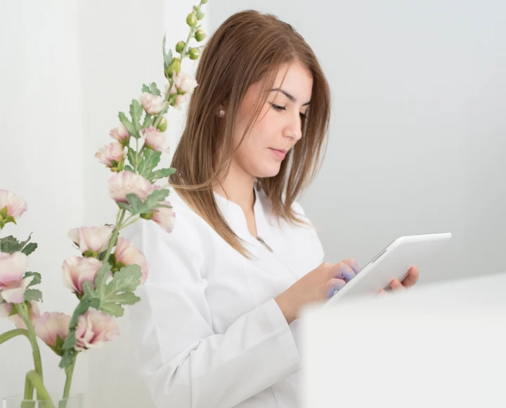 Ragazza vestita di bianco controlla il tablet in sicurezza alla reception di un centro di bellezza